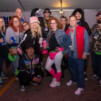 group of friends in costume under big tent during Wyandotte's 80s vs 90s Halloween Pub Crawl