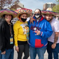4 people at Cinco Block Party, three wearing sombreros and two in face masks