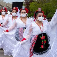 4 traditional Mexican dancers in beautiful lace skirts and white face masks