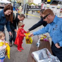 police officers handing out candy to two little girls during Royal Oak Spooktacular