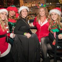 five ladies dressed in Santa dresses at bar during Wyandotte's Santa Pub Crawl