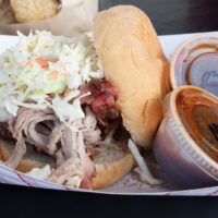 pulled pork sandwich with coleslaw and two cups of bbq sauce at Wyandotte's Swiggin' Pig