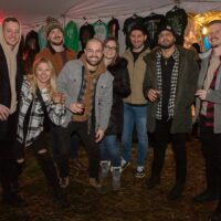 group of friends in coats holding glasses under white tent at Wyandotte's Winter Beer Cocktail Fest