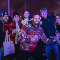 group of friends in ugly Christmas sweaters holding cocktail glasses at Wyandotte's Winter Beer Cocktail Fest