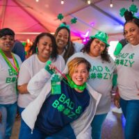 group of happy party goers with green and shamrock gear