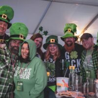 group of party goers in green leprechaun hats and gear