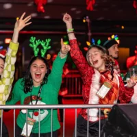 Ladies in holiday themed outfits cheering.